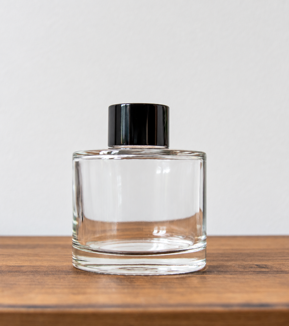 Reed diffuser bottle with black cap in clear